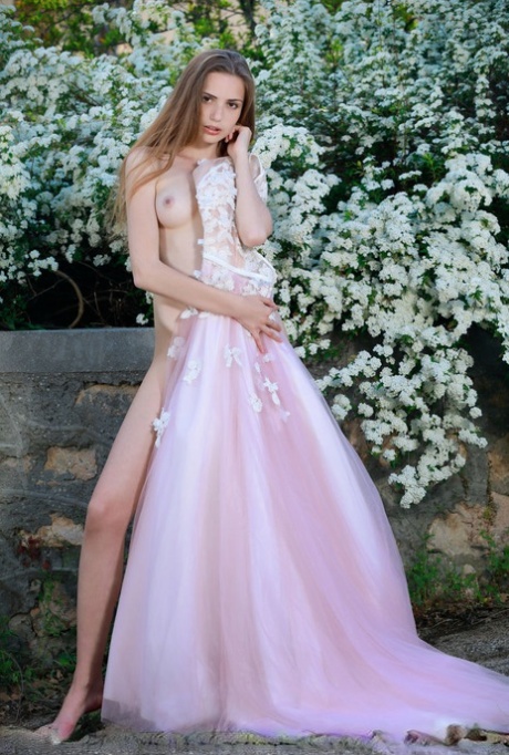 Beautiful girl Elle Tan slips off wedding dress to pose nude in garden