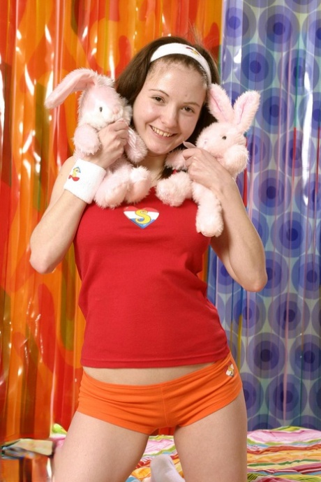 Busty teen doll Maya D poses nude with her stuffed rabbits and masturbates
